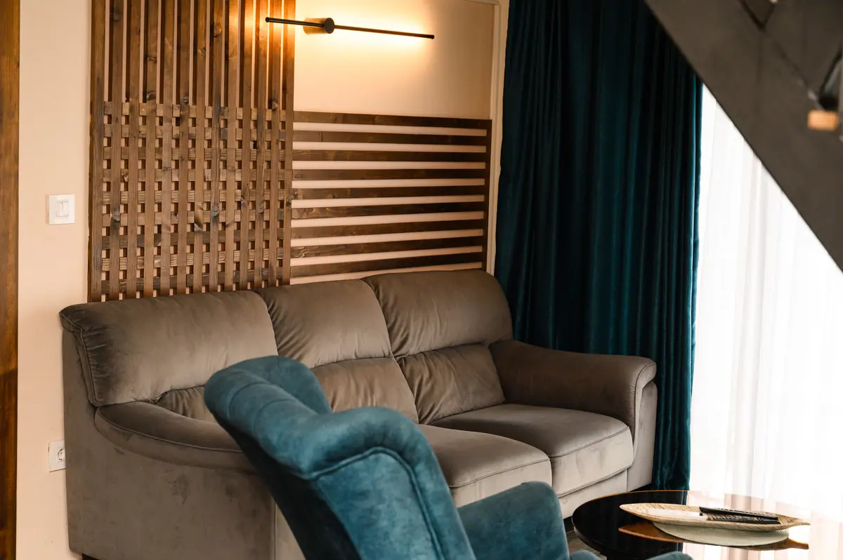 Siva sofa i drveni zid sa svetlom u dnevnom boravku